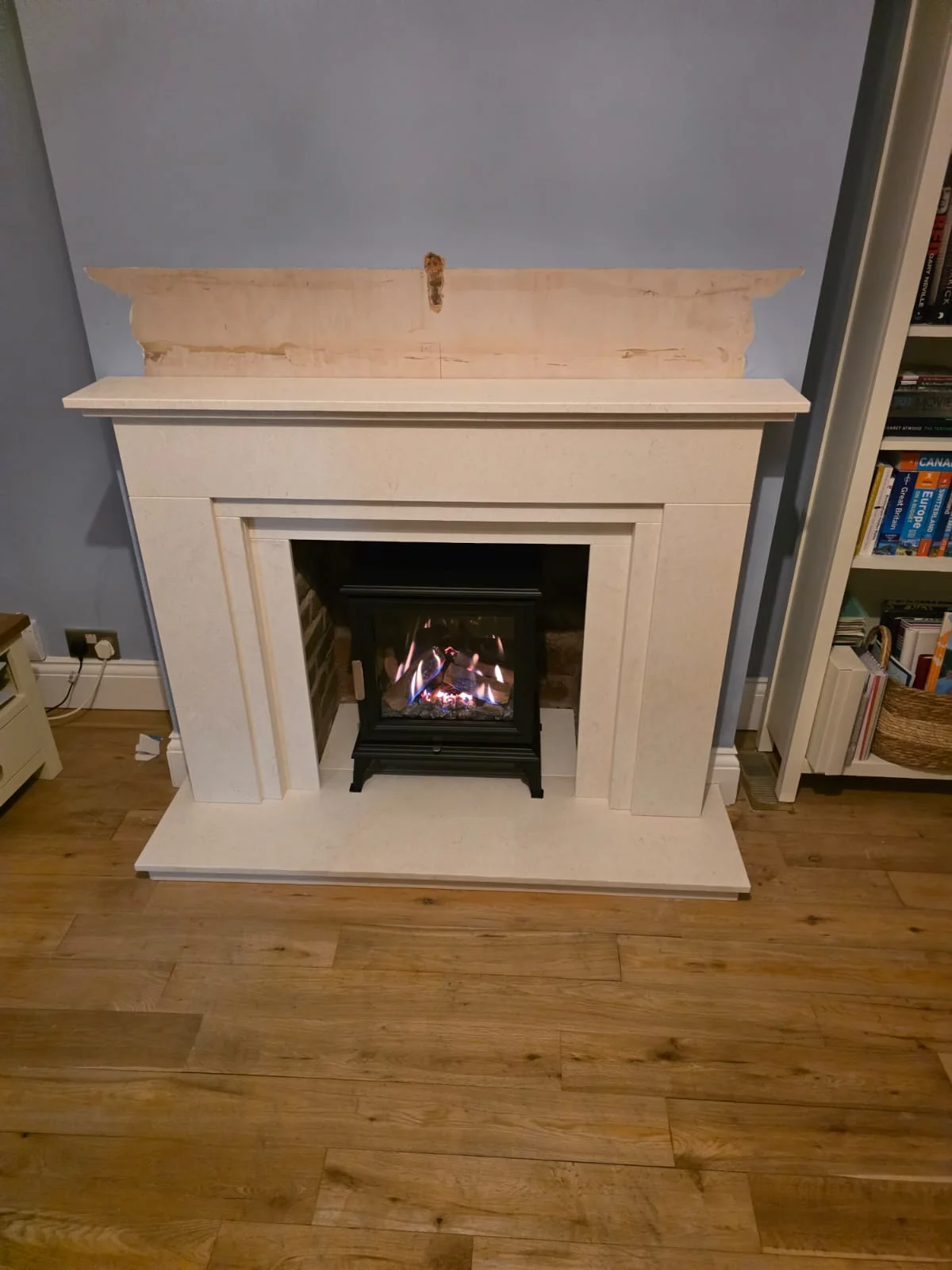 Waldon limestone fireplace with a lit black Wildfire Ravel 400C gas stove in Birmingham